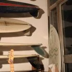 Go Yukioka's surfboard collection racked up a wall beside a guitar